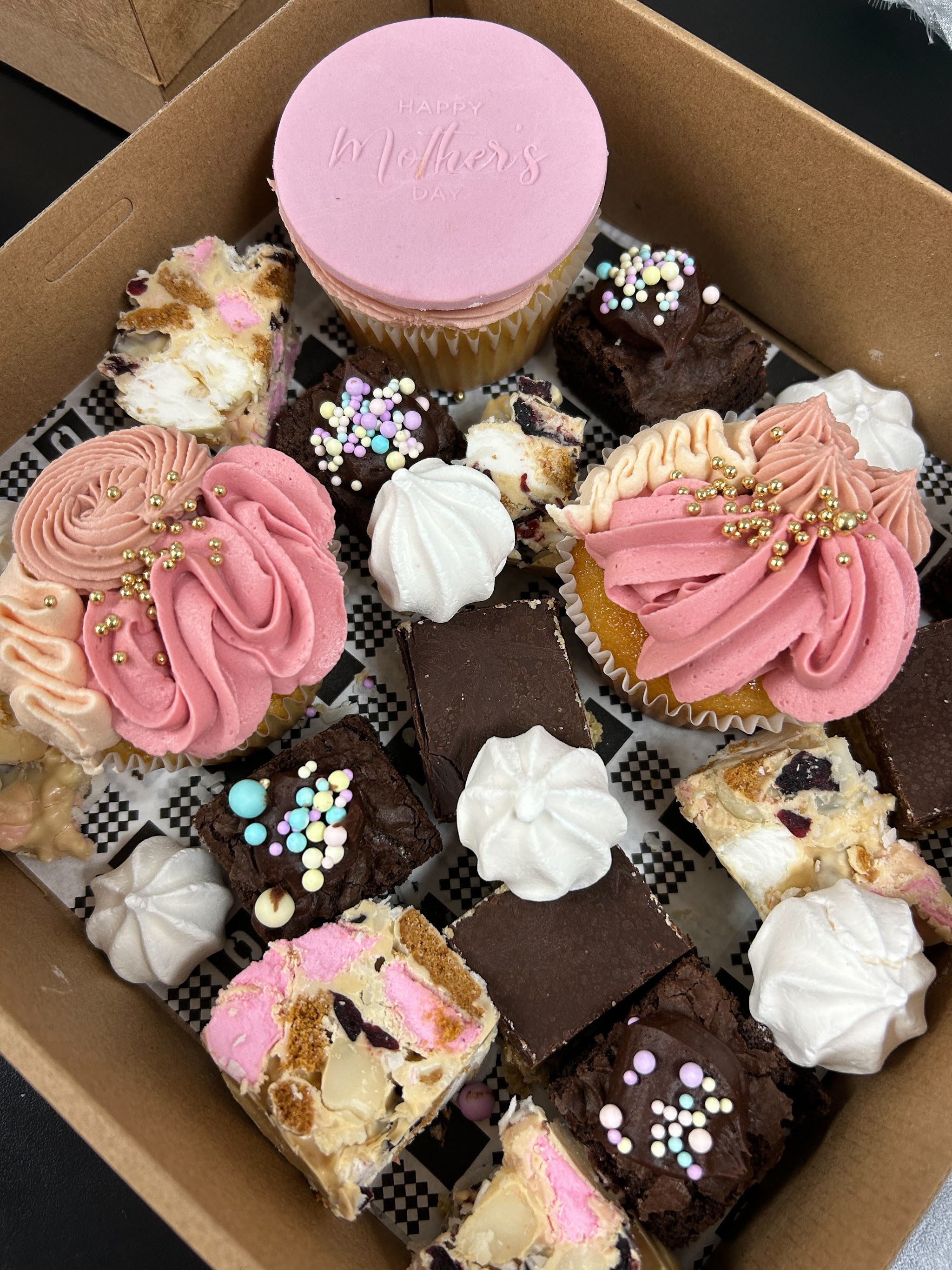 A box of cupcakes, brownies, rocky road and meringues