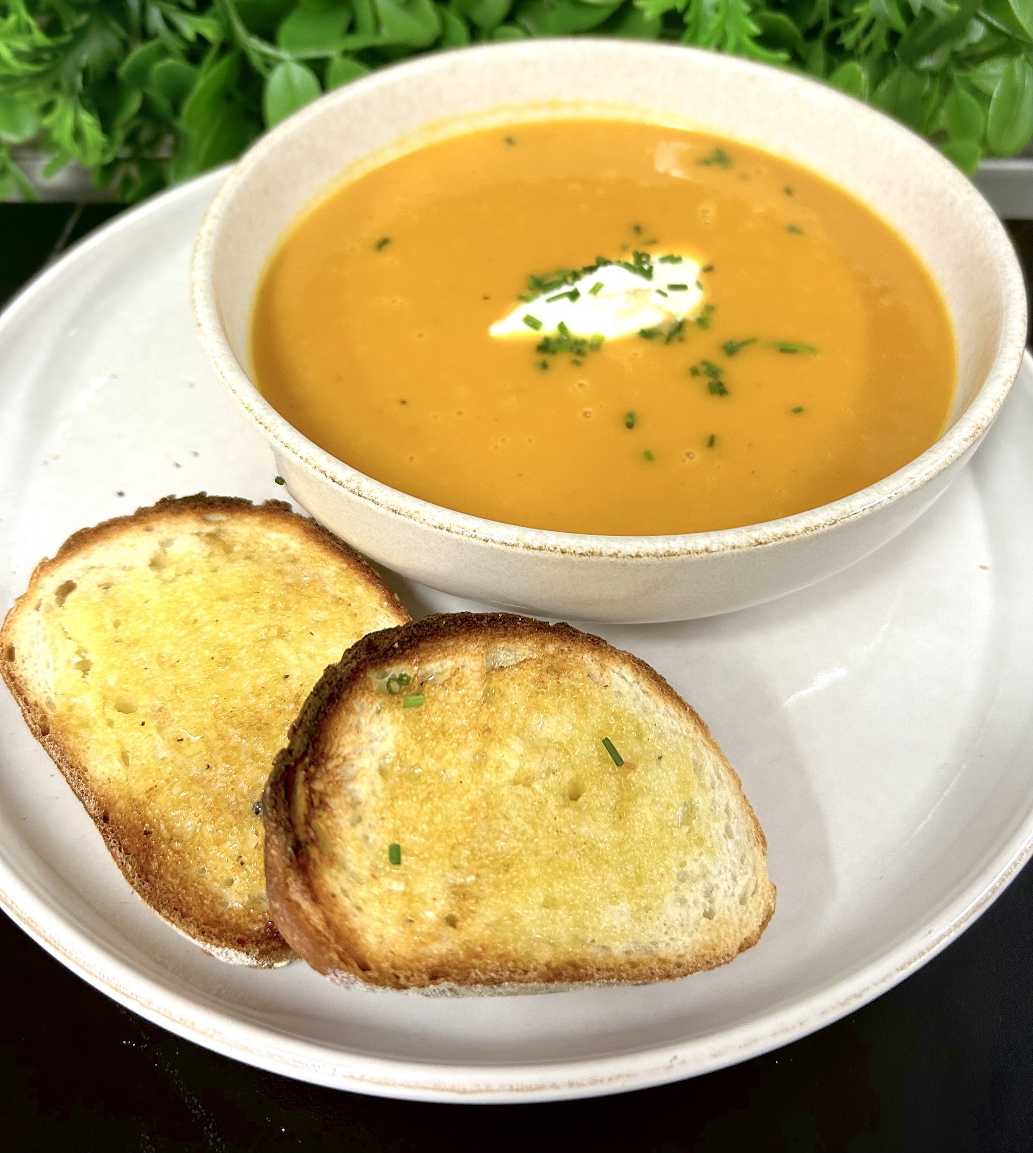 Pumpkin soup with sour cream, chives and garlic bread